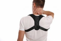Man wearing an upper back brace (posture brace)